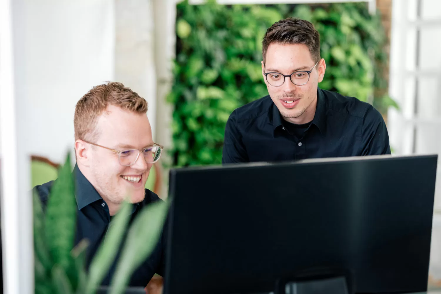 WordPress-Wartung von Agentur-Profis Zwei zertifizierte WordPress-Experten überprüfen Wartungsprozesse auf einem Bildschirm.