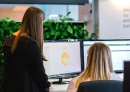 Mitarbeiterinnen gemeinsam vor einem Bildschirm mit Daten