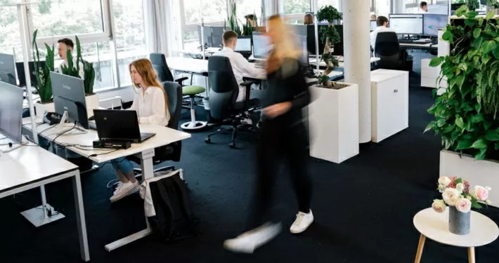 Das Büro in Stuttgart - Mitarbeiterin läuft durch das Bild und Mitarbeiter arbeiten
