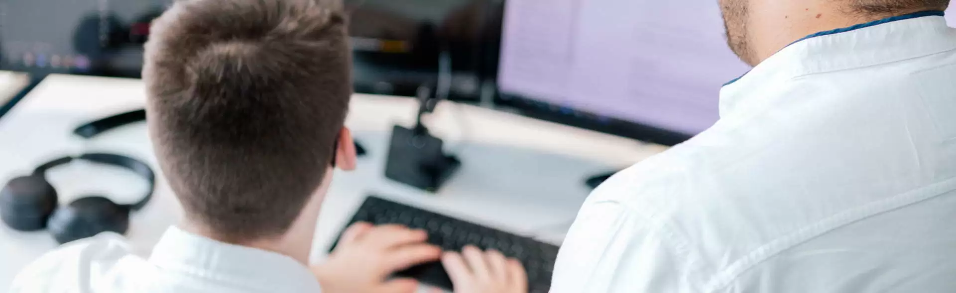 Magento Entwickler Besprechung Zwei Mitarbeiter besprechen zusammen etwas an einem Computer