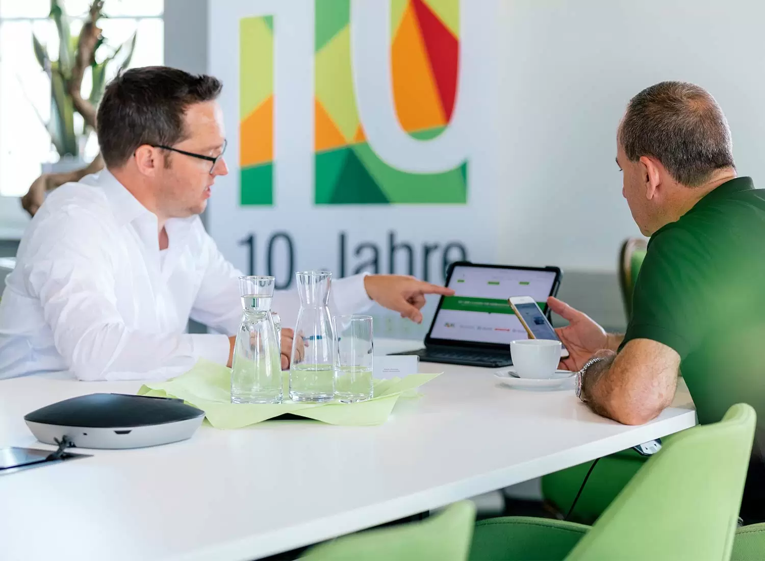 Online-Marketing Beratung Zwei Menschen sitzen an einem Tisch und schauen sich Dinge auf einem iPad an.