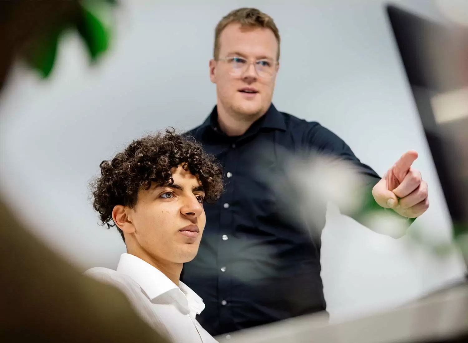 TYPO3 Mitarbeiter Zwei Mitarbeiter arbeiten gemeinsam an einem Computer in der TYPO3-Agentur