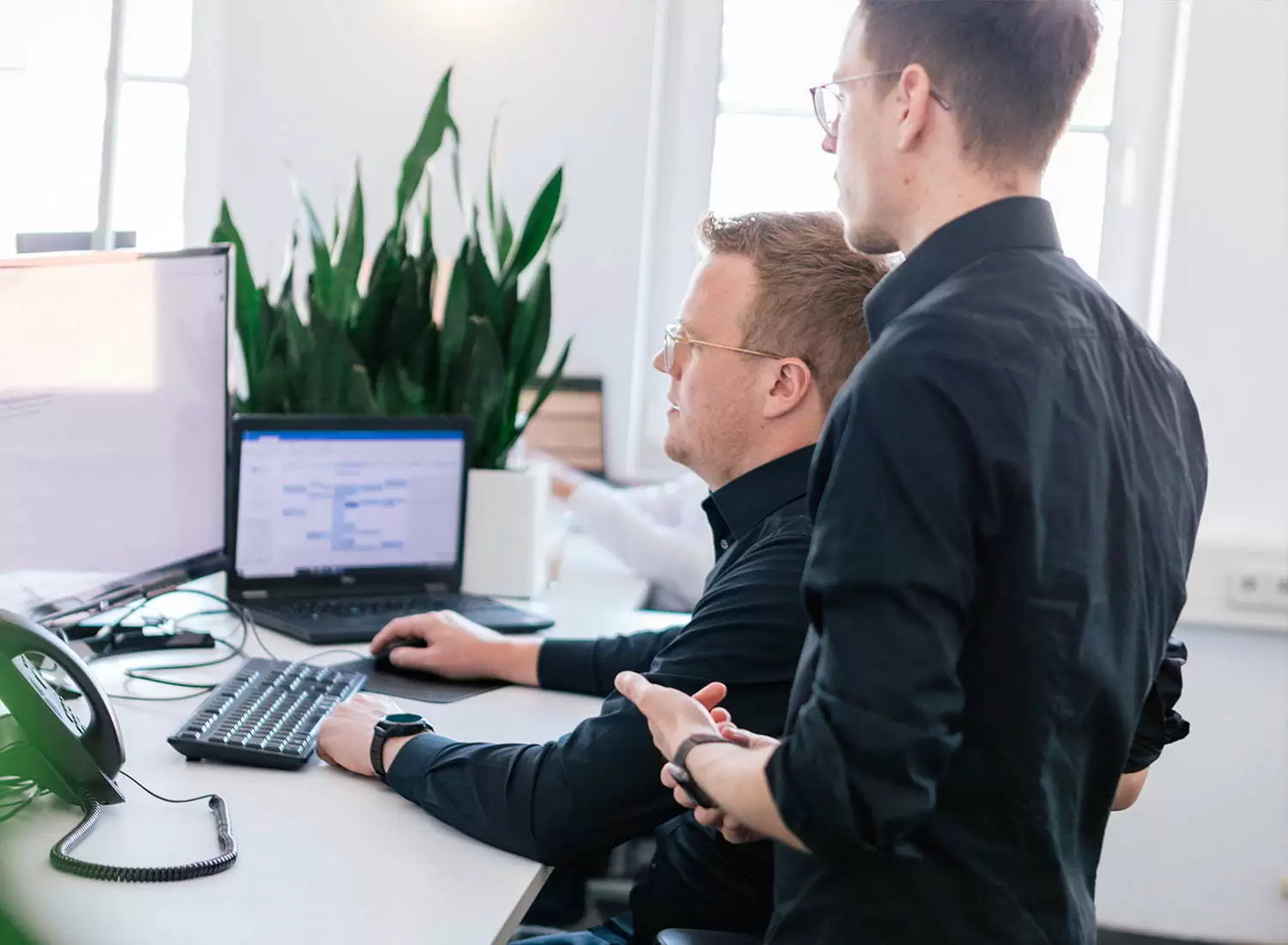 Magento-Agentur Besprechung Zwei Mitarbeiter besprechen sich an ihrem Arbeitsplatz in der Magento-Agentur