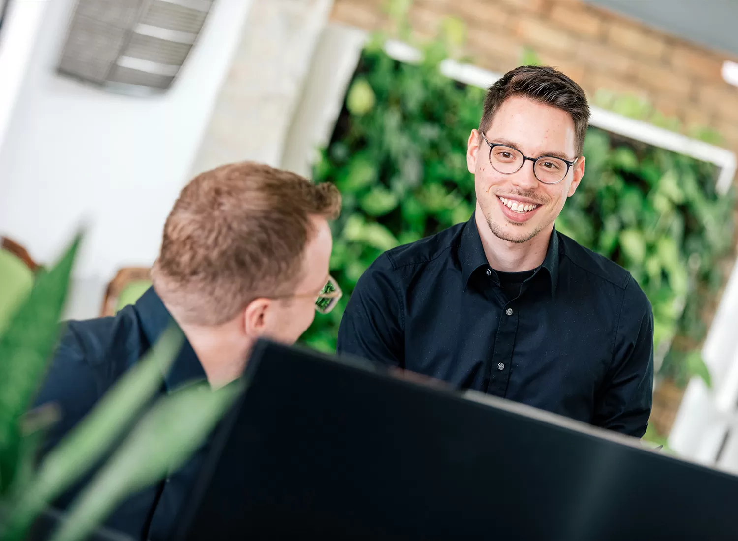 Online-Marketing-Profis Zwei Online-Marketing-Profis besprechen sich vor einem Computer