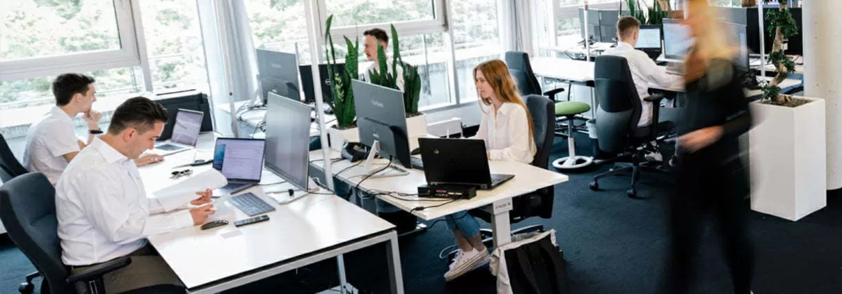 Das Büro in Stuttgart - Mitarbeiterin läuft durch das Bild und Mitarbeiter arbeiten