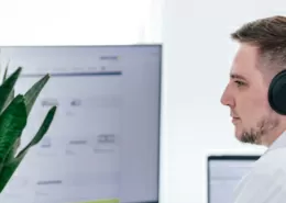 Mitarbeiter von Team TYPO3 am Arbeitsplatz mit Kopfhörern