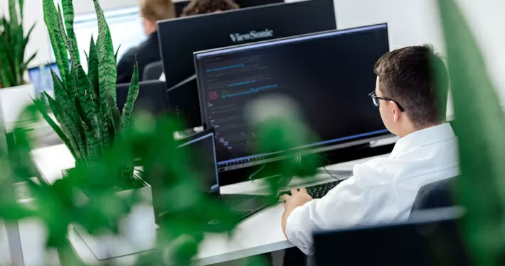 Grünes Büro mit Mitarbeitern, die am PC arbeiten