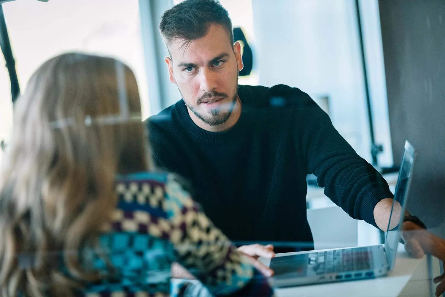 Besprechung im Stuttgarter-Büro Mitarbeiter bespricht sich konzentriert mit einem anderen Mitarbeiter in Stuttgart