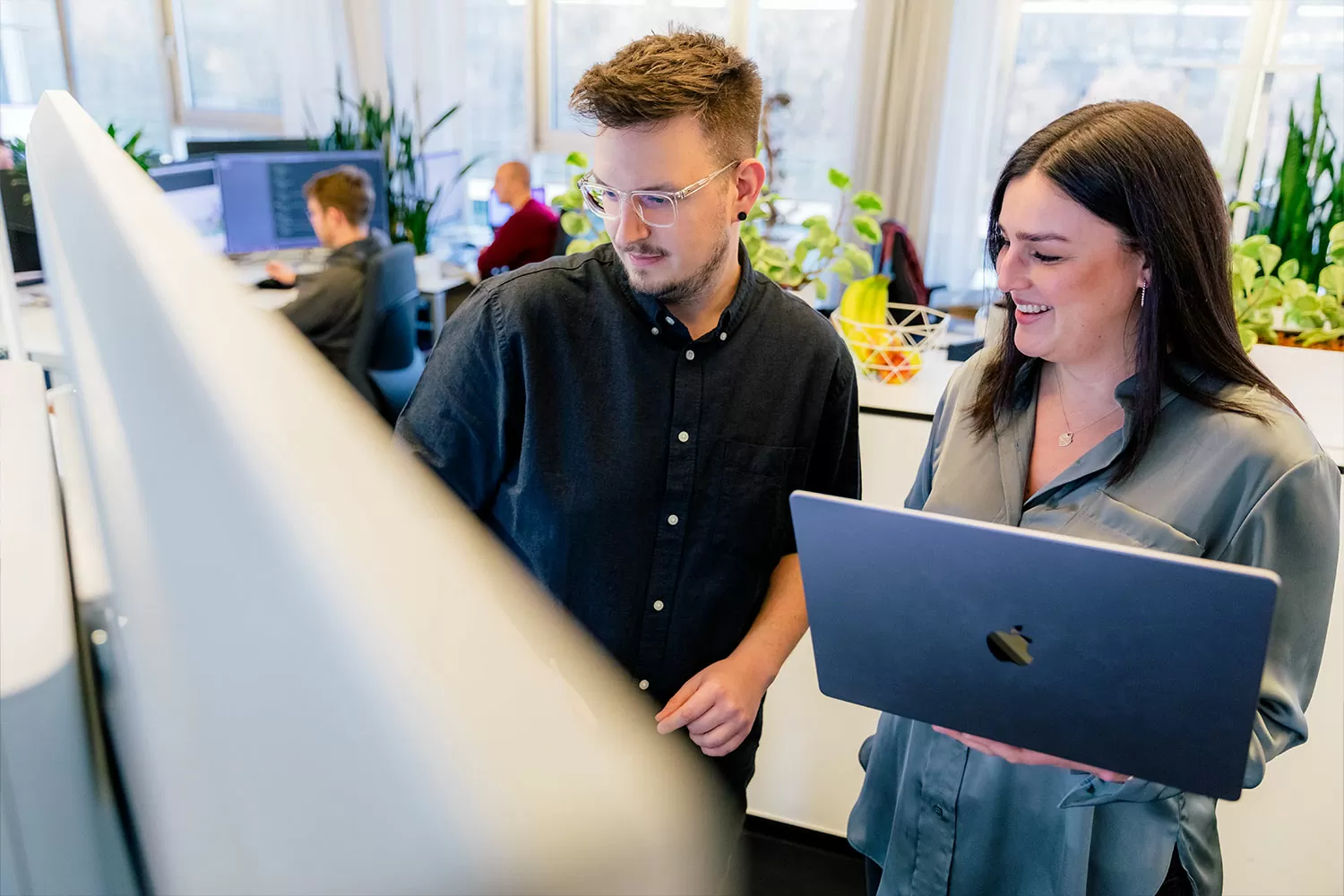 Magento Entwickler Besprechung Drei Mitarbeiter besprechen zusammen etwas an einem Computer