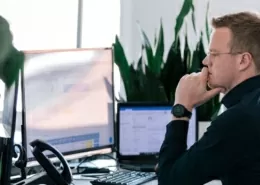 Mitarbeiter sitzt konzentriert am PC und arbeitet.