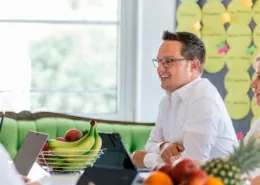 Personen sitzen in einem Konferenzraum und besprechen ein weiteres Vorgehen.